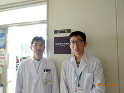 白衣を着た二人の男性が並んで立っている様子。