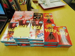 机の上に並べられた多くのポッキーの箱。