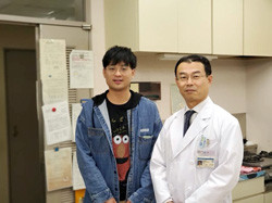 二人の男性が室内で並んで立っている。