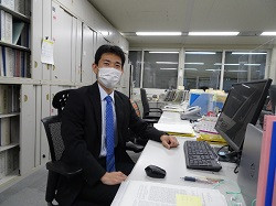 執務室のデスクに座っている様子