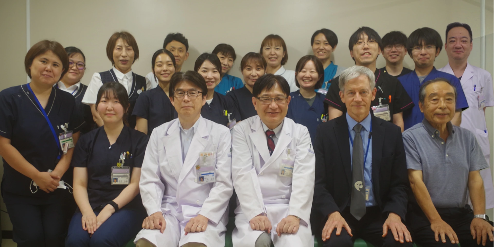 福島県立医科大学輸血部の医療スタッフが集合した写真。医師、看護師、医療技師、医療事務が笑顔で並んでいる。