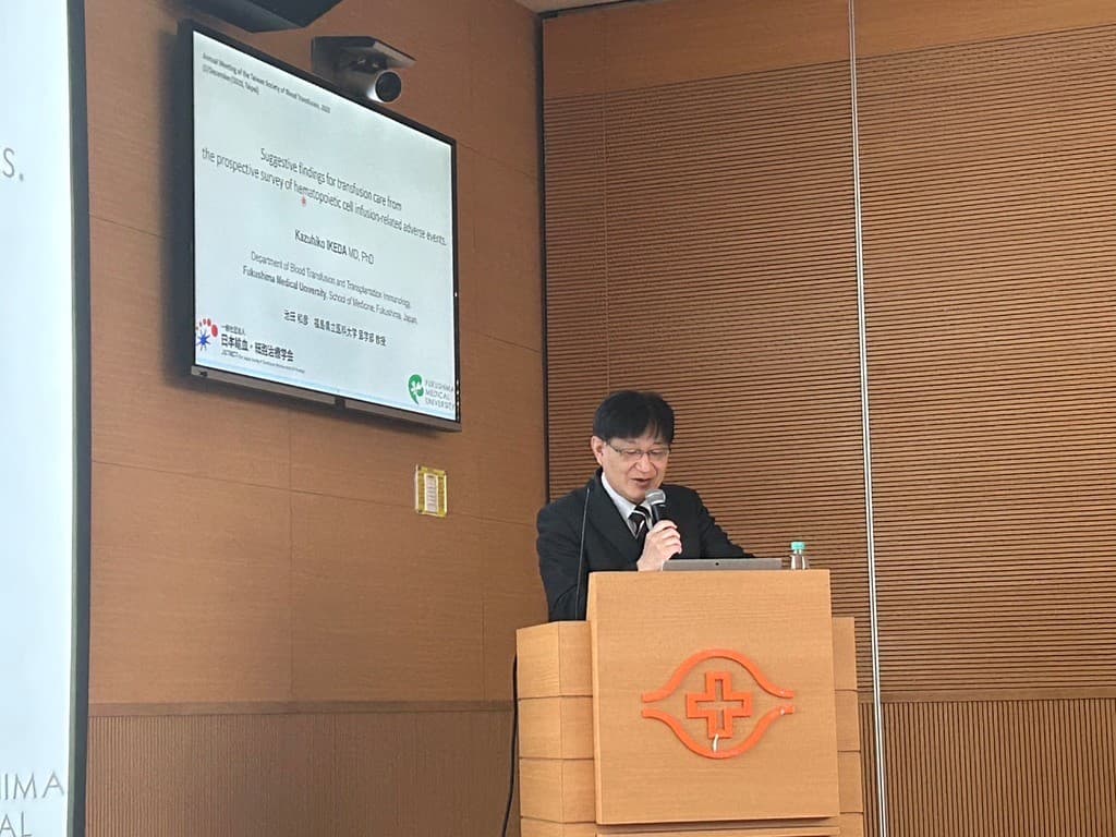 池田和彦教授が台湾輸血学会で講演している様子。背景にはプレゼンテーション用のスクリーンが見える。