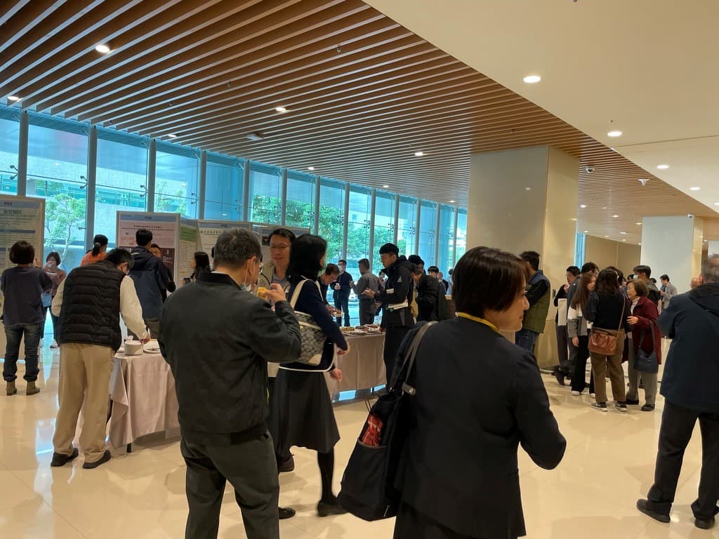 台湾輸血学会のポスター会場で、参加者が研究内容について議論している様子。