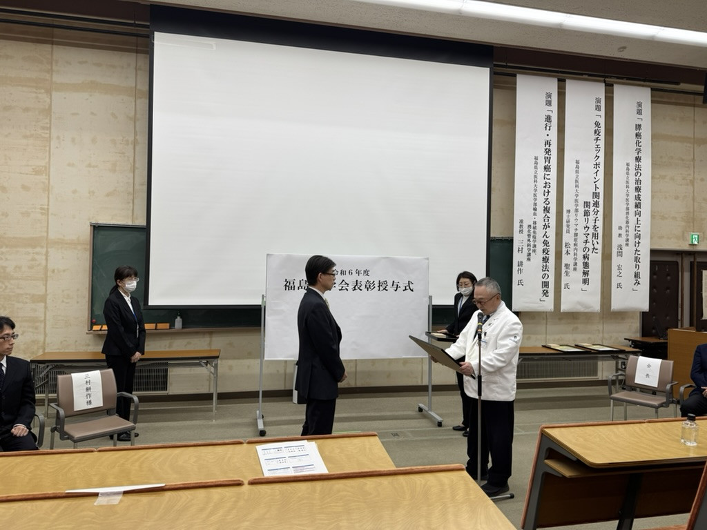 三村耕作准教授が福島医学賞を受賞する授賞式の様子。壇上で表彰される場面。