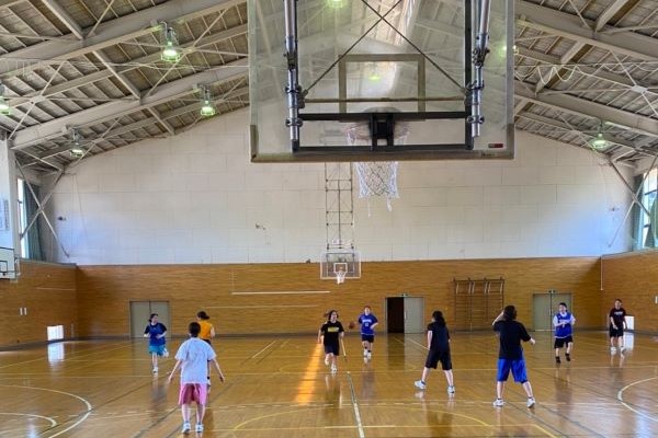 女子バスケットボール部のメンバーが試合形式の練習を行っている体育館の様子。