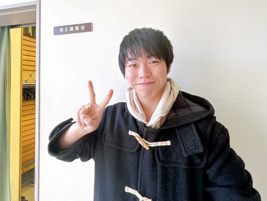福島県立医科大学の教室前でピースサインをする在校生の笑顔。