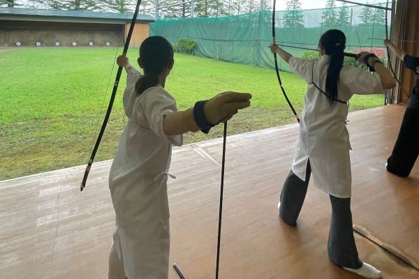 弓道場で部員たちが弓道に励む様子。