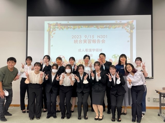 2023年度統合実習報告会に参加した学生たちが笑顔でポーズをとっている様子。