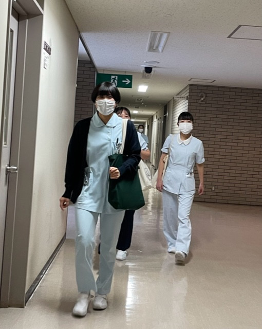 実習初日の病棟で、看護師の学生たちが緊張しながら歩いている様子。