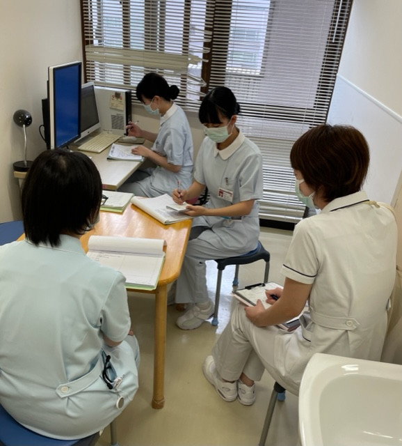領域別実習で教員から指導を受ける学生たちが、重要ポイントをメモしている様子。