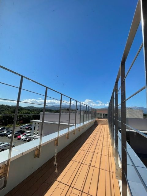 外廊下から見た福島県立医科大学の風景。快晴の空と周囲の建物が広がる。