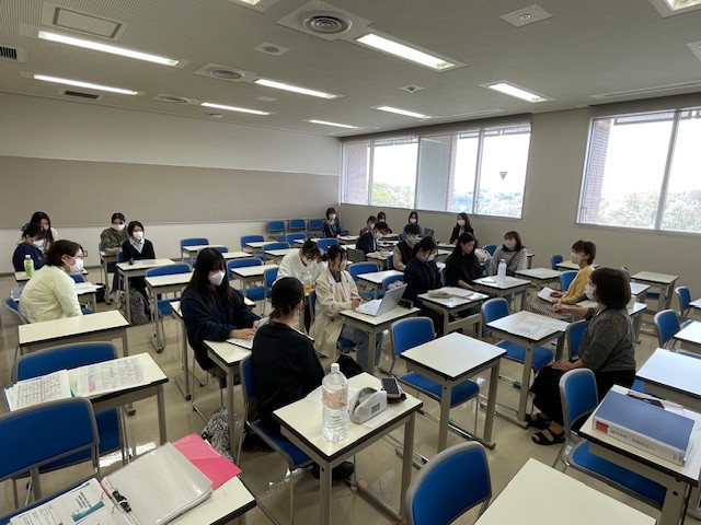 看護学部の教室で、学生たちがテーマ発表を行っている様子。4年生の学生たちが熱心に議論している。