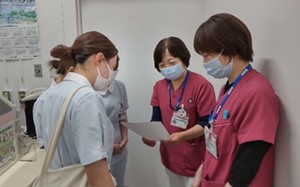 医療現場での実習報告を行う看護師たちと学生の様子。