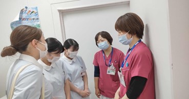 医療現場での実習中、看護師と学生が話し合っている様子。