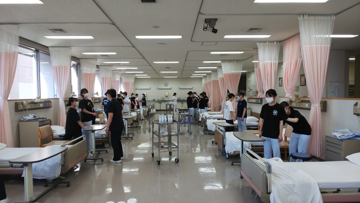 看護技術の授業中、学生たちが病室で実習を行っている様子。