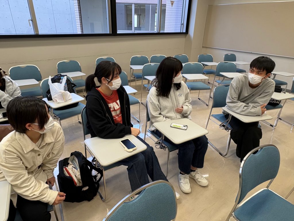 グループでディスカッションを行う学生たちが、マスクを着用して意見を交わしている教室の様子。