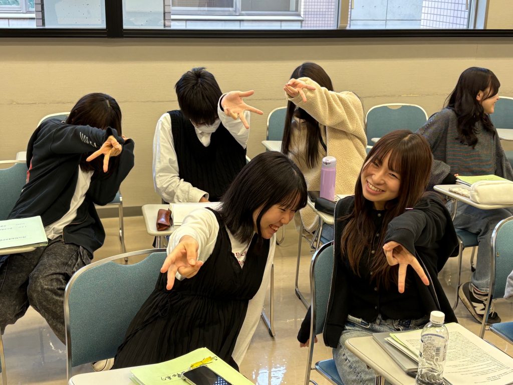 実習を終えた学生たちが楽しそうにポーズを決めている教室の様子。