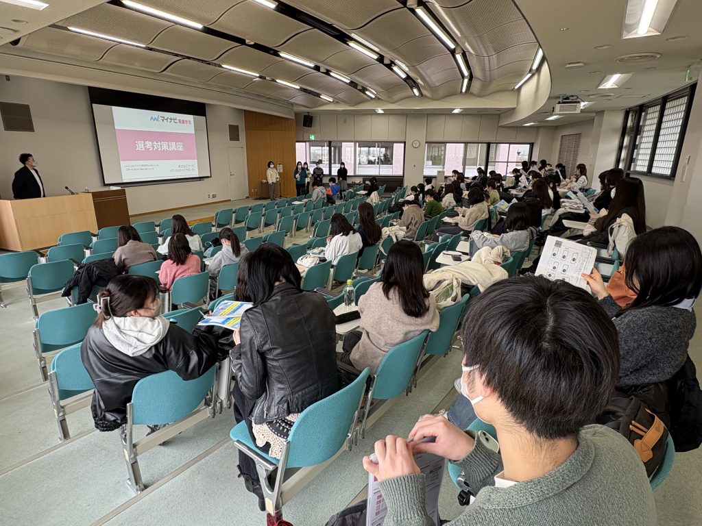 就職支援セミナーで参加者が資料を手にし、講演を聴いている様子。