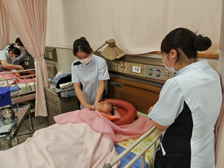 看護技術の演習で洗髪を行う学生たちが、リラックスした雰囲気の中で実習している様子。