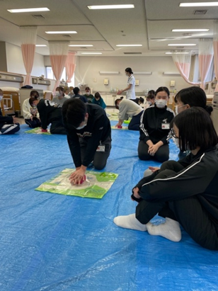 看護技術の演習で救命救急処置を学ぶ学生たちが真剣な表情で取り組んでいる様子。
