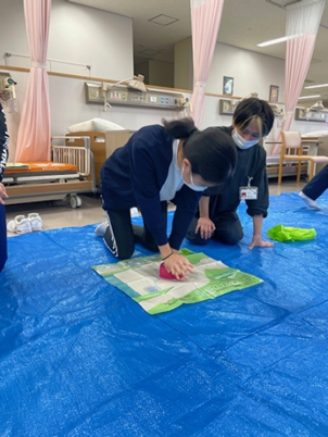 看護技術の演習で、学生が救命救急処置を学ぶ様子。チームワークを重視している。