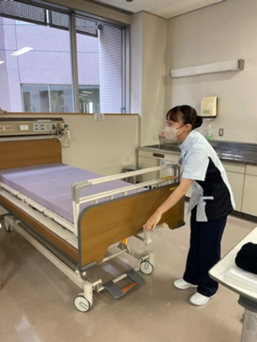 看護技術を学ぶ学生が病院のベッドを整えている様子。