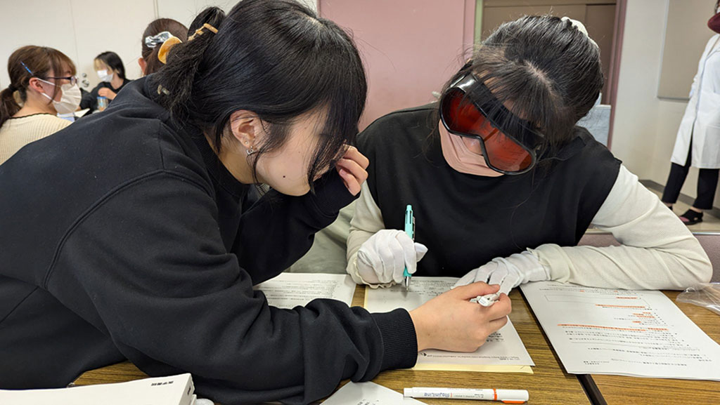 高齢者の疑似体験を行う学生たちが、食事介助やとろみ食の体験をしている様子。