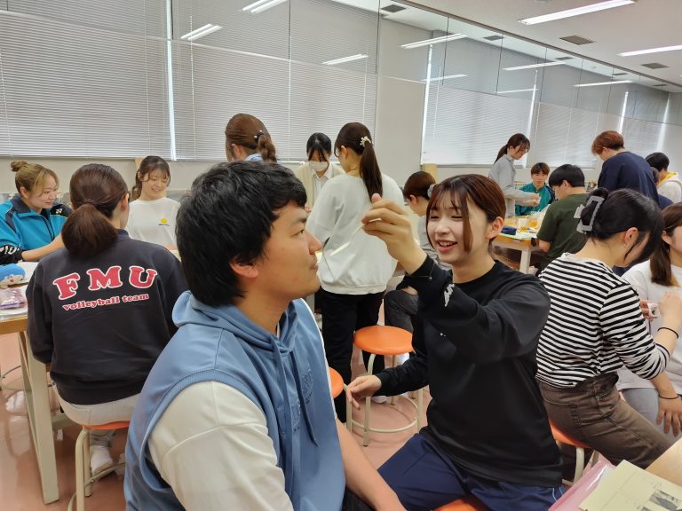 高齢者の疑似体験を通じて、食事介助を行う学生たちの様子。
