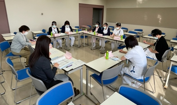 2022年度「臨地実習教育会議」での参加者が円形のテーブルを囲んで議論している様子。