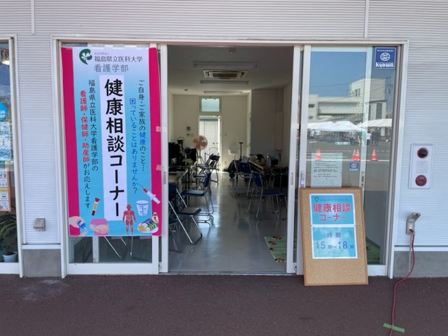 健康相談コーナーの入口が写っており、看板や椅子が並ぶ明るい室内の様子が見える。
