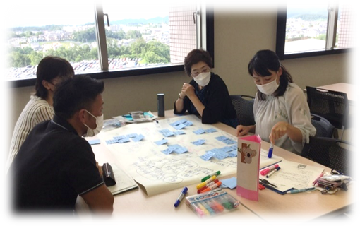 看護学実習に関する教員の役割を話し合う4人の参加者が集まる会議の様子。