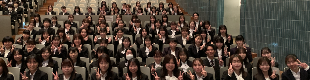 令和6年度の入学式で、看護学部の新入生たちが笑顔でポーズをとっている様子。
