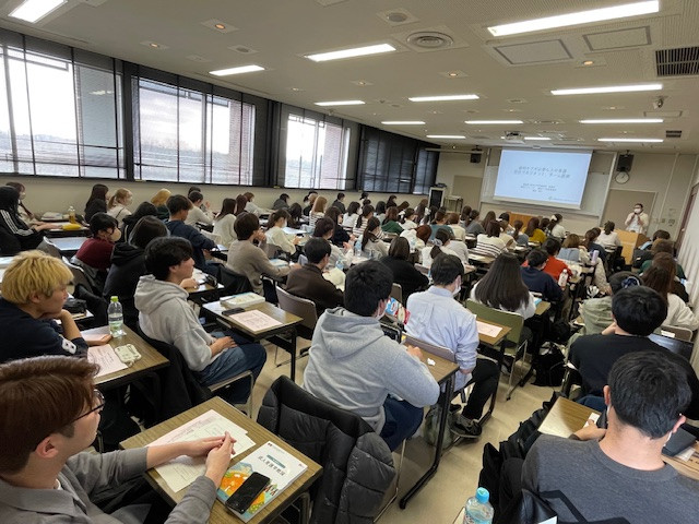 学部講義が始まり、男子学生が多い教室で真剣に授業を受ける様子。