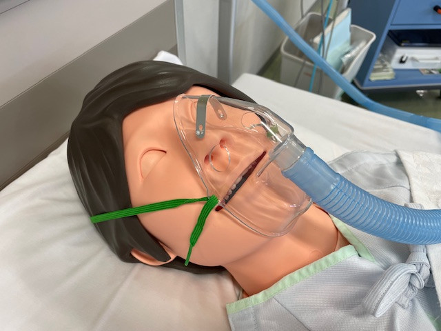 看護学部のシミュレーション用マネキンが酸素マスクを装着している様子。