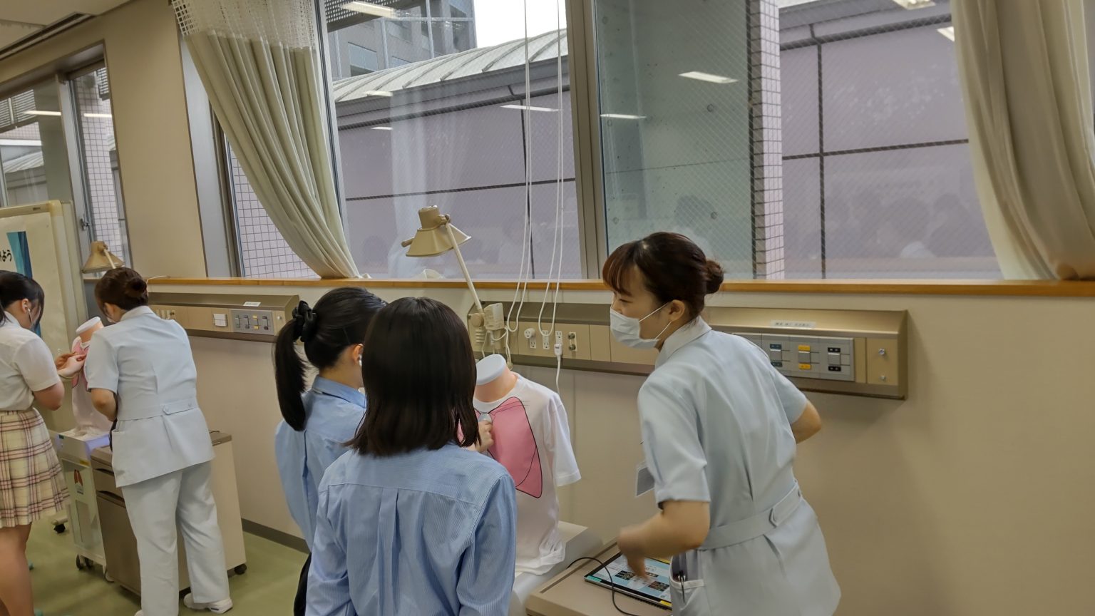 肺の聴診コーナーで聴音トレーニングを行う看護学生たちの様子。