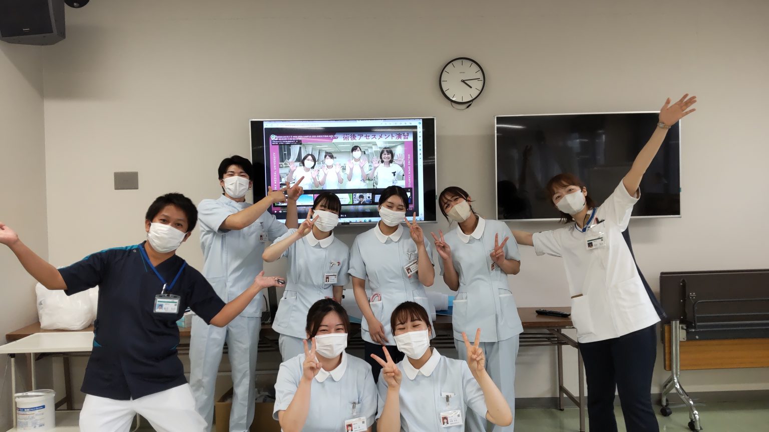 看護学部のオープンキャンパスで笑顔を見せる学生たちが、マスクを着用しながらポーズを決めている様子。