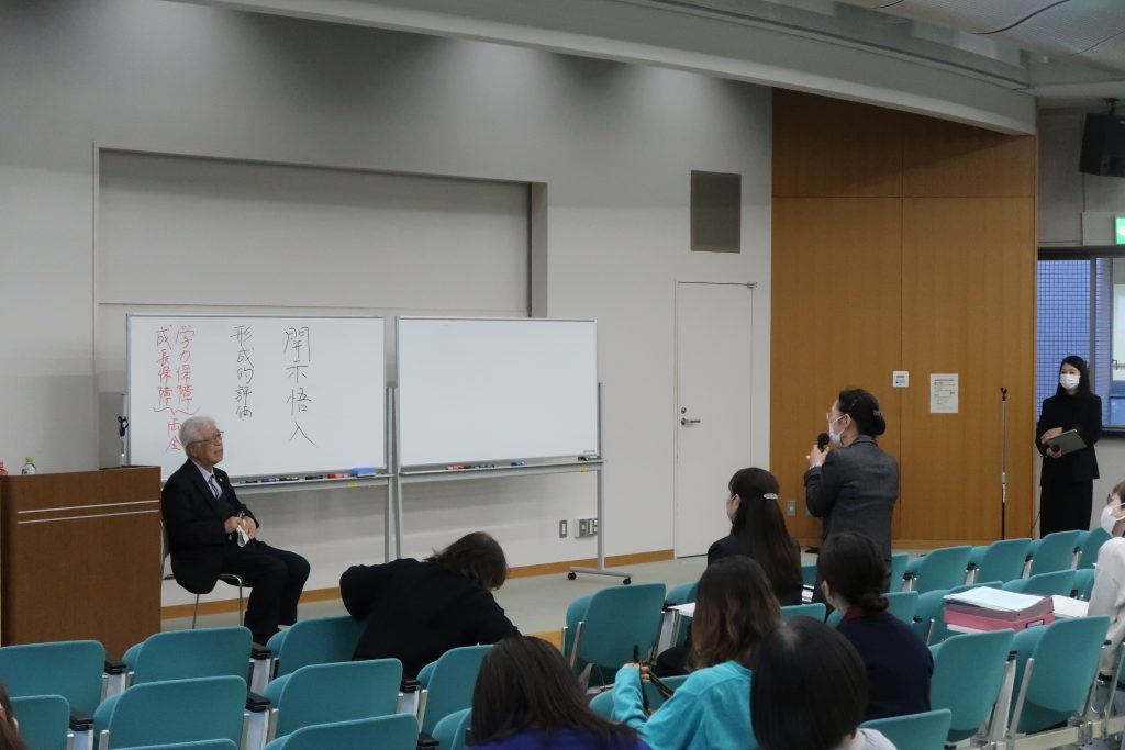 看護学部の研修会で講演を行う講師と質問する参加者の様子。