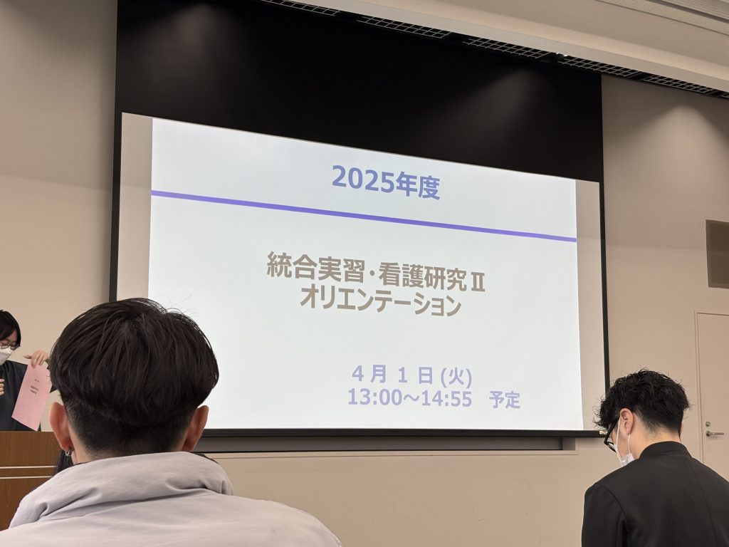 2025年度のオリエンテーションが行われている教室の様子。前方にプレゼンテーションが映し出されている。