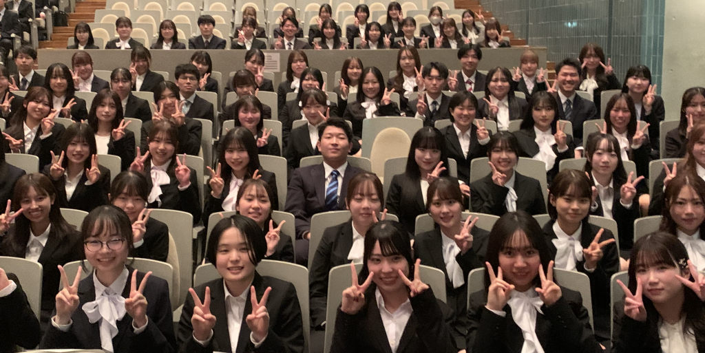 福島県立医科大学の入学式で、看護学部の新入生たちが笑顔でピースサインをしている様子。