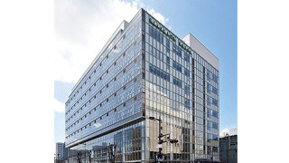 A modern building of Fukushima Medical University, School of Health Sciences, under a clear blue sky.