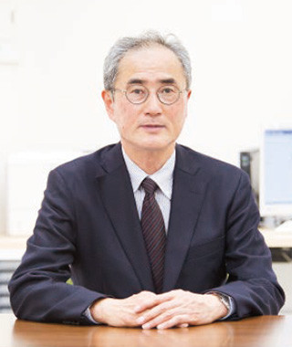 A professional portrait of Dr. Satoru Suzuki, Executive Director at the Thyroid and Endocrine Center, seated at a desk.
