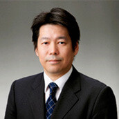 Portrait of Yoshiyuki Suzuki, Chairman of the Department of Radiation Oncology, in a professional setting.