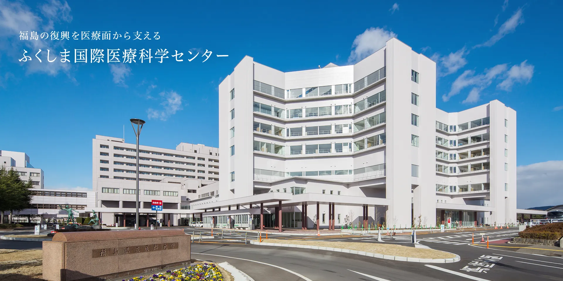 ふくしま国際医療科学センターの外観と周囲の景観を捉えた写真。青空の下、近代的な建物が広がる。