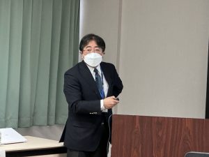 福島国際医療科学センターの見学会でプレゼンテーションを行う男性。