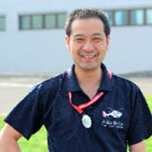 福島県立医科大学の講座主任、長谷川有史教授が笑顔でポーズをとっている写真。