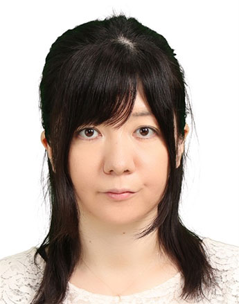 小橋友理江助教のポートレート写真。白い背景に黒髪の女性が正面を向いている。