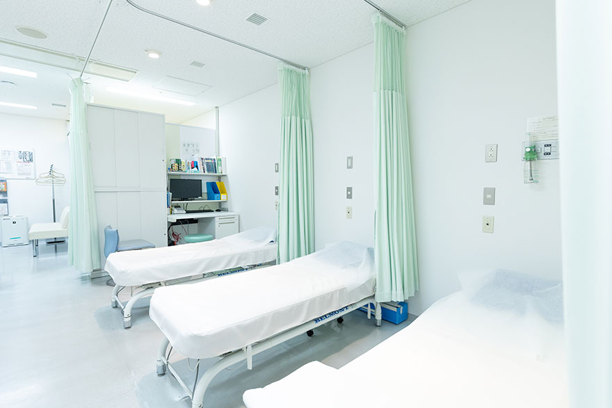 白いシーツが掛けられた診察室のベッドが並んでいる様子。