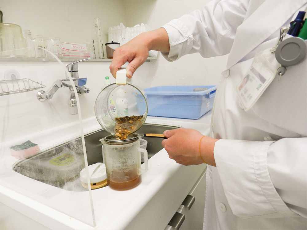 煎薬を容器に移し替えている様子。