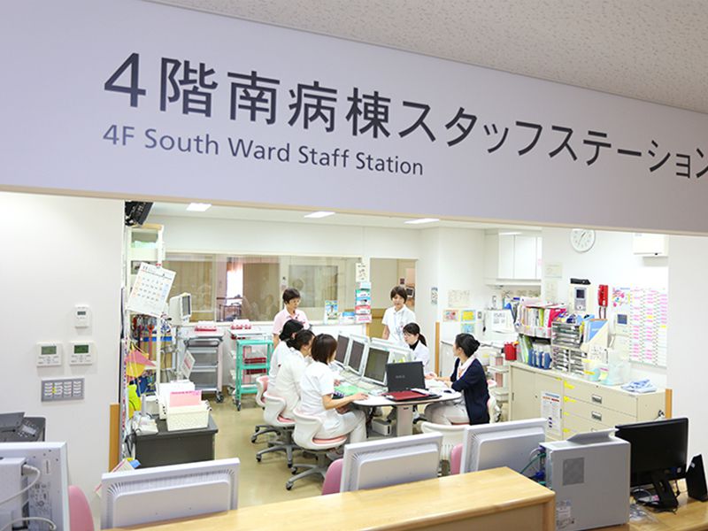 4階南病棟スタッフステーションで、医療スタッフがデスクでコンピュータを使用しながら業務に取り組んでいる様子。