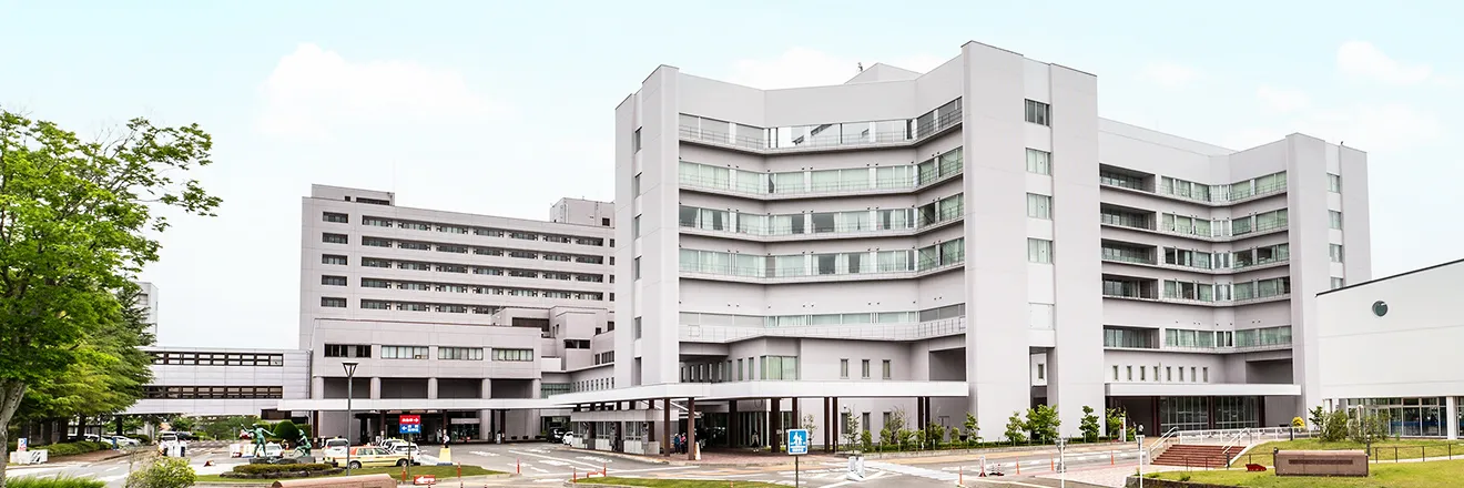 福島県立医科大学の近代的なキャンパス建物が広がる風景。緑豊かな環境に囲まれている。